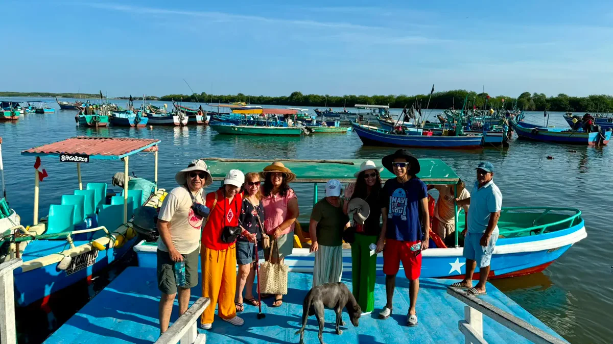 Pasajeros junto a embarcaciones en Puerto Pizarro