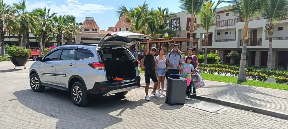 Pasajeros junto a un vehículo de Tumpis Tours con el maletero abierto