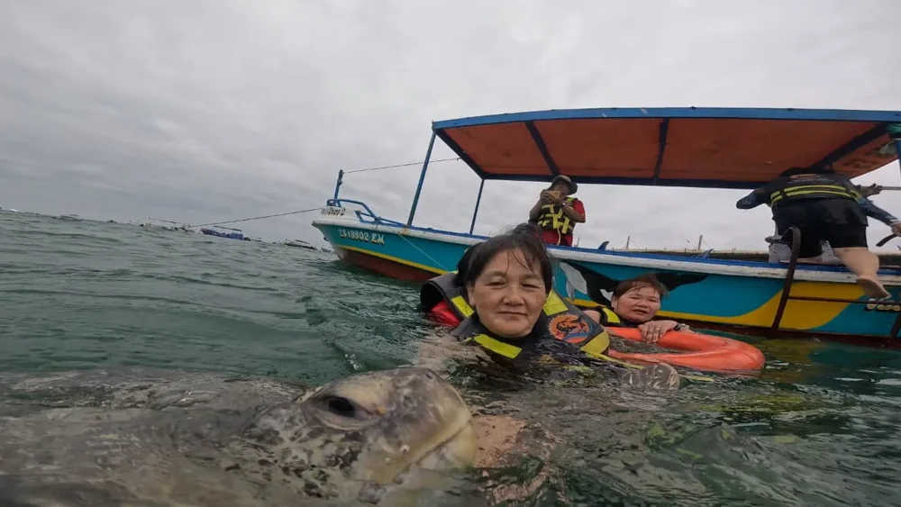 Viajeros en el mar junto a una embarcación durante la visita