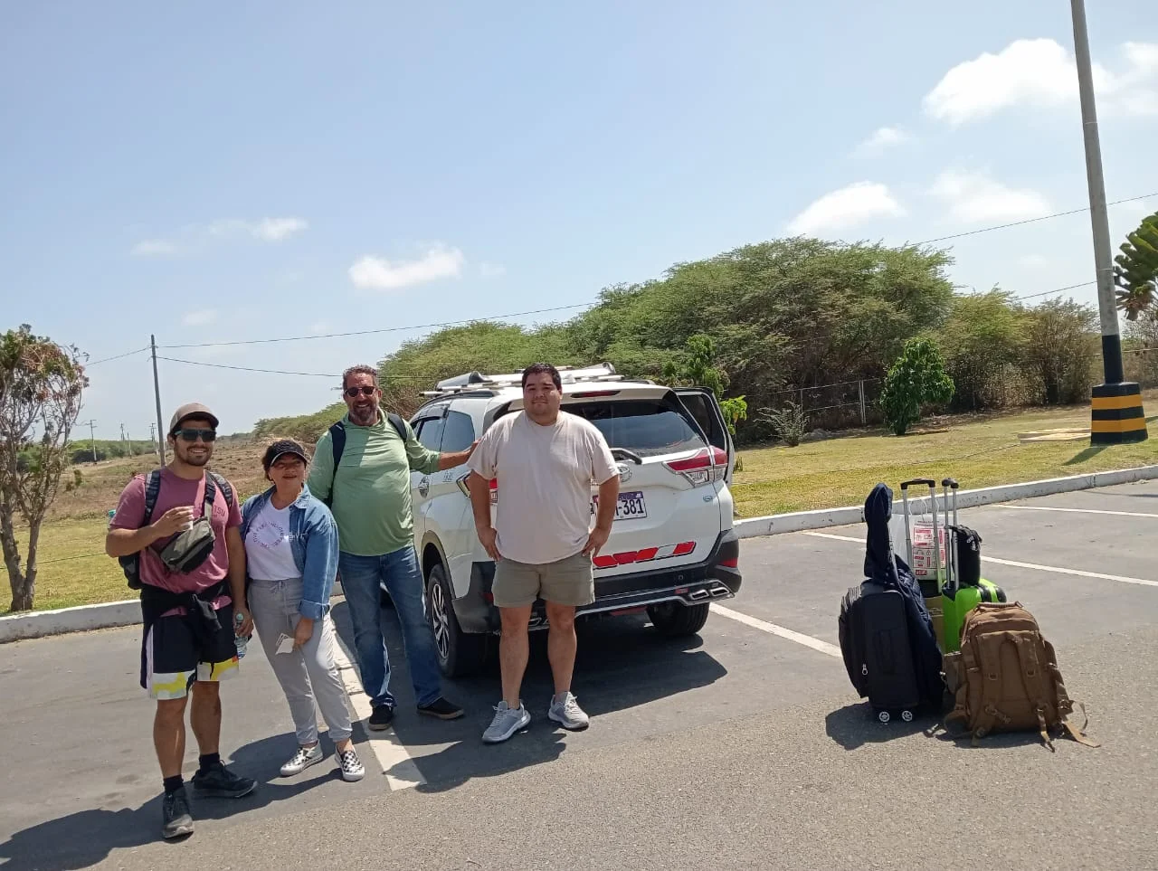 Pasajeros y equipaje junto a un vehículo de Tumpis Tours en Tumbes